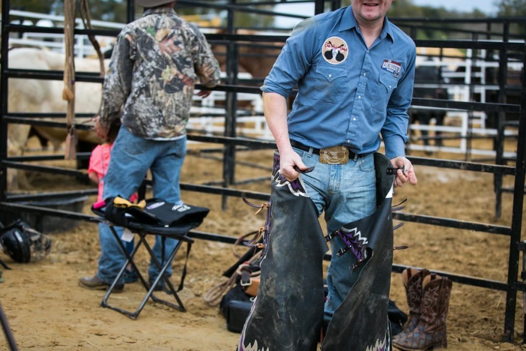 A cowboy changes out of his chaps at the county fair championship rodeo, by NYC photojournalist, Kelly Williams