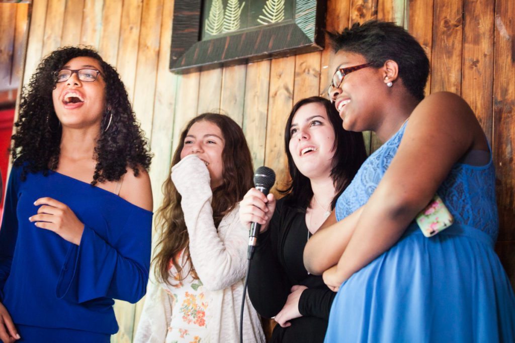 Kids performing karaoke, by NYC bat mitzvah photographer, Kelly Williams