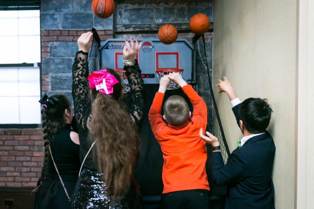 Guests playing basketball at a Brooklyn bar mitzvah at 26 Bridge, by Brooklyn bar mitzvah photographer, Kelly Williams