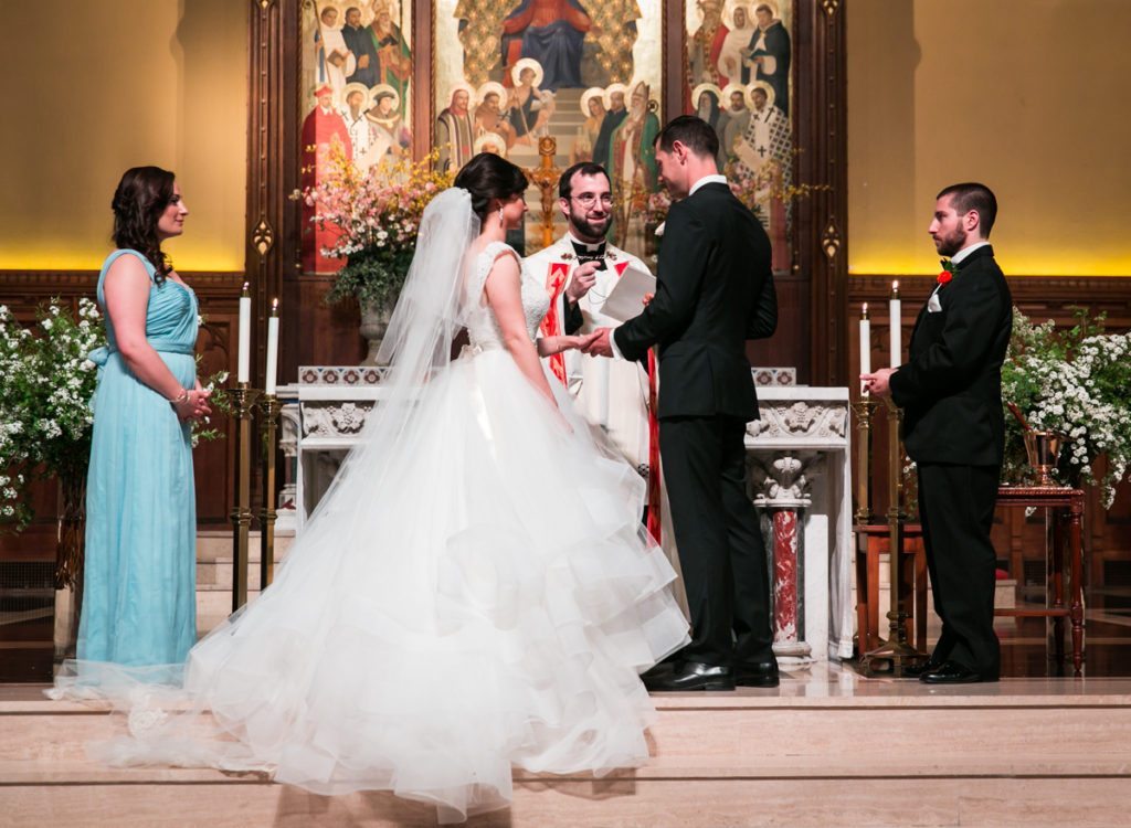 Exchanging rings at a Fordham University Church wedding ceremony