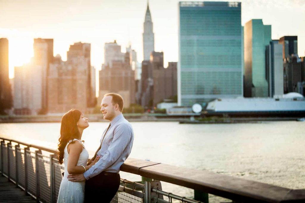 Couple leaning against railing at a Gantry Plaza State Park engagement shoot