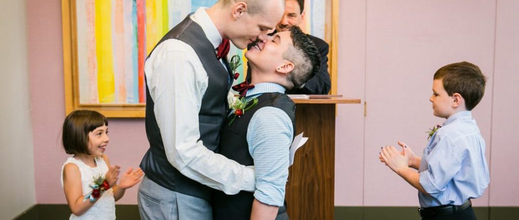 Two grooms kissing after a NYC LGBTQ City Hall wedding ceremony