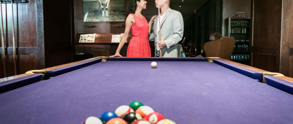 Couple at end of pool table during a Hudson Hotel engagement shoot