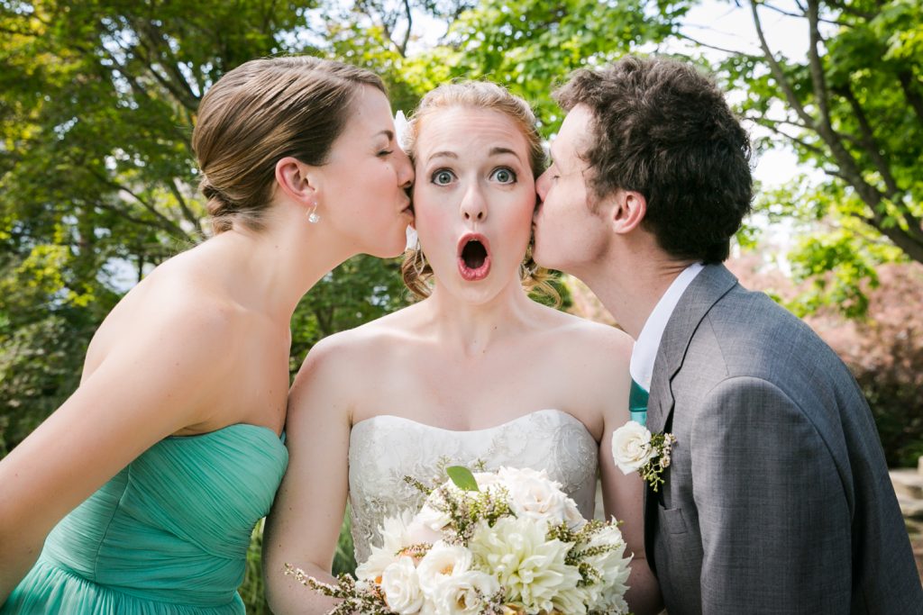 Man and woman kissing bride on both cheeks at a Round Hill House wedding