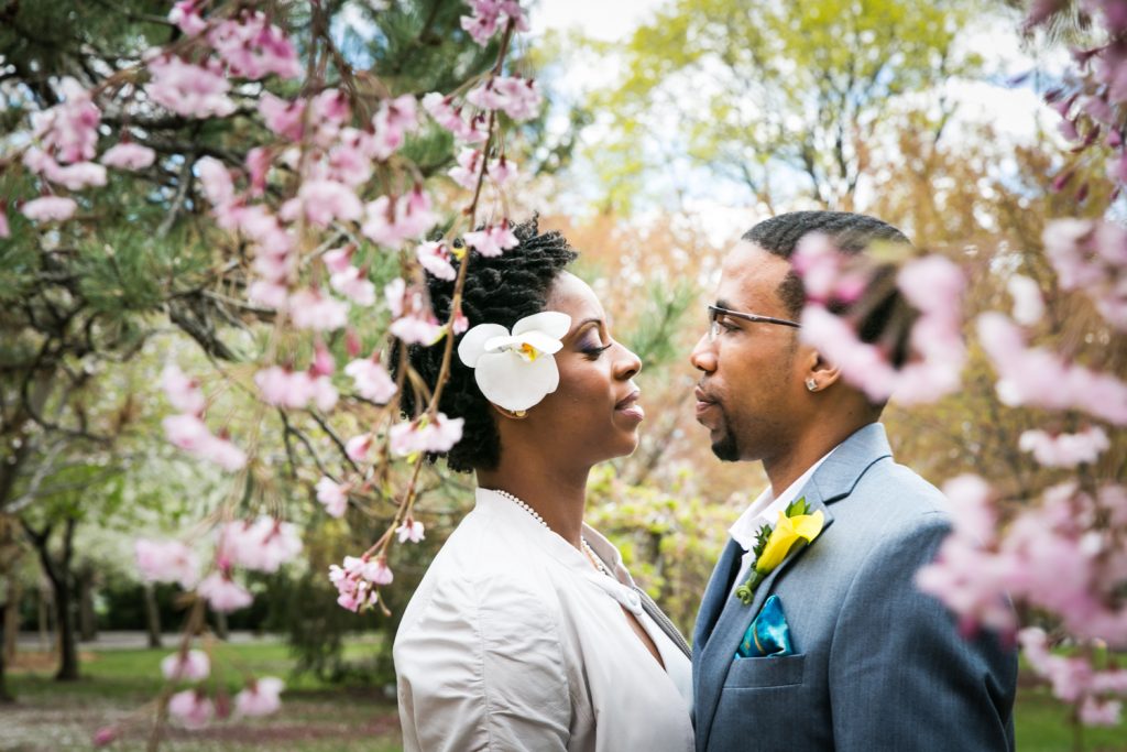 Portrait of bride and groom under cherry blossom trees at a Flushing Meadows Corona Park wedding