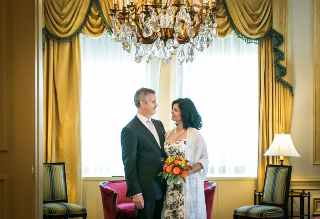 Couple looking at each other underneath chandelier at a Waldorf Astoria wedding