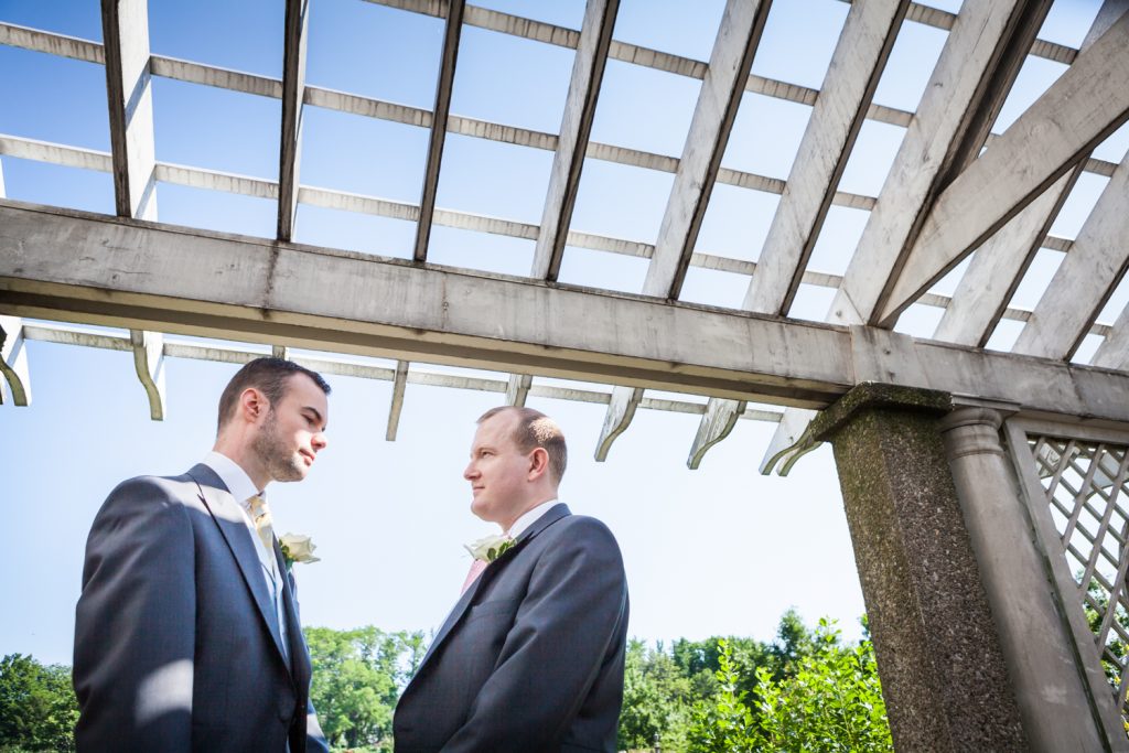 Two men exchanging vows under trellis at an Brooklyn Botanic Garden wedding