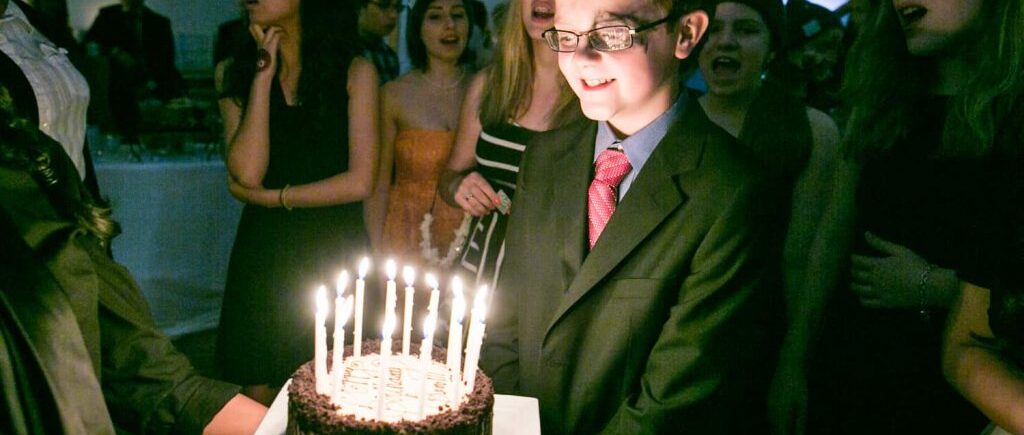 Boy blowing out birthday candles at a birthday party