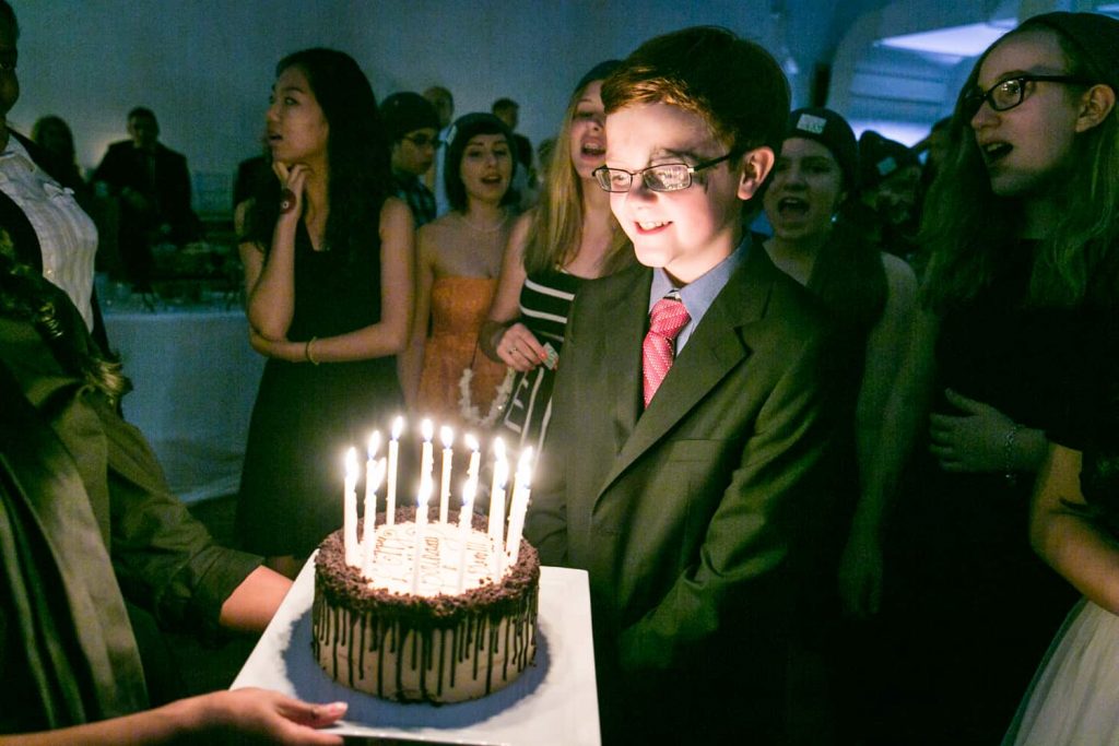 Boy blowing out birthday candles at a birthday party