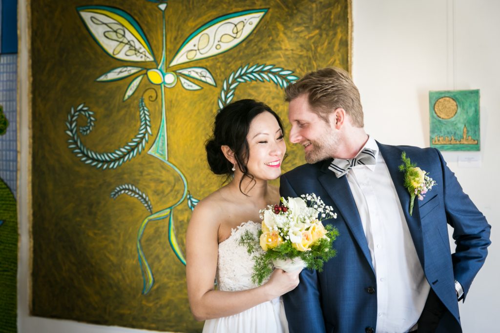 Bride and groom in front of painting at an Astoria restaurant wedding