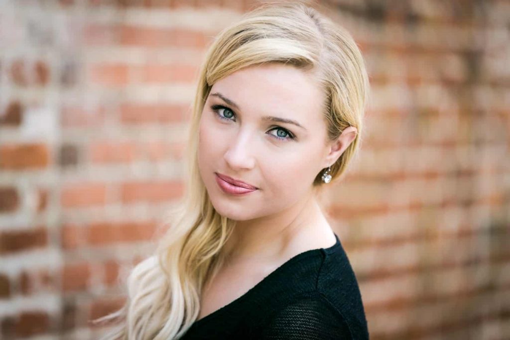 Blond actress in front of brick wall for an article on actor headshot tips