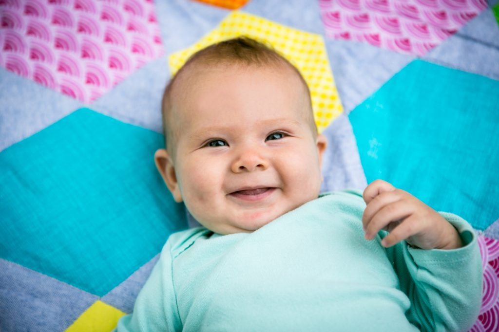 Smiling baby on quilt