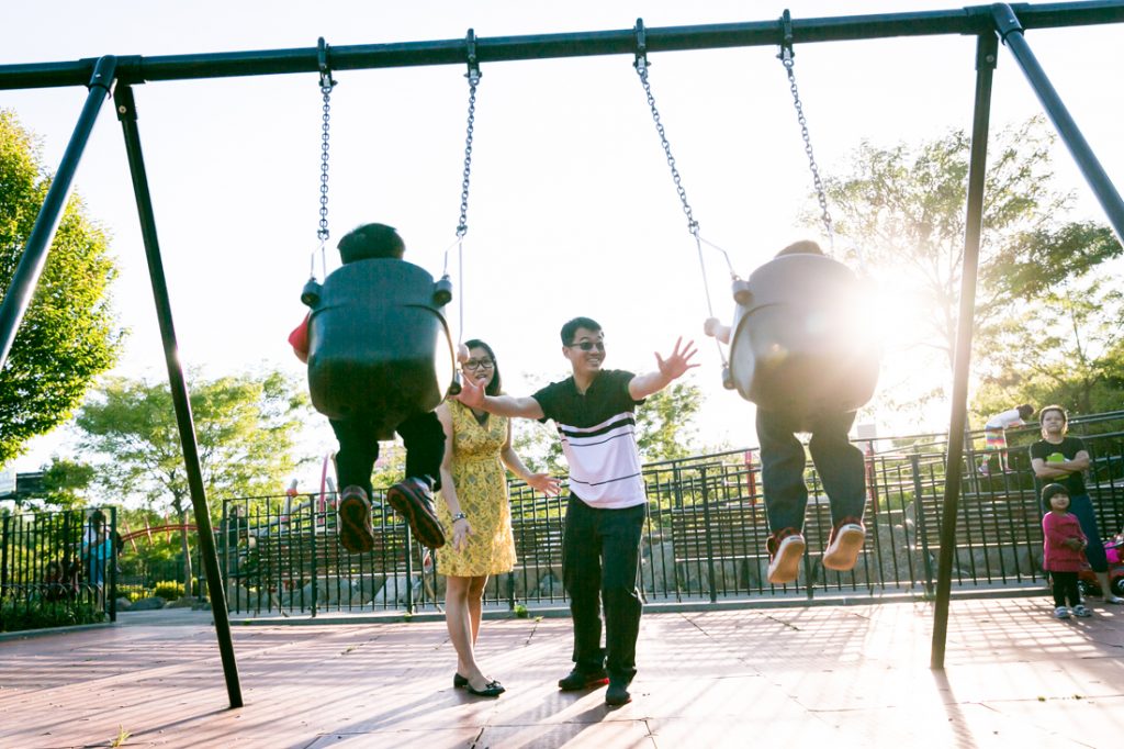 Parents pushing kids in swings at Elmhurst Park