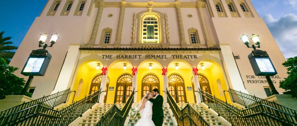 Bride and groom kissing on stairs of entrance to Harriet Himmel Theater for an article on how to have an unplugged wedding