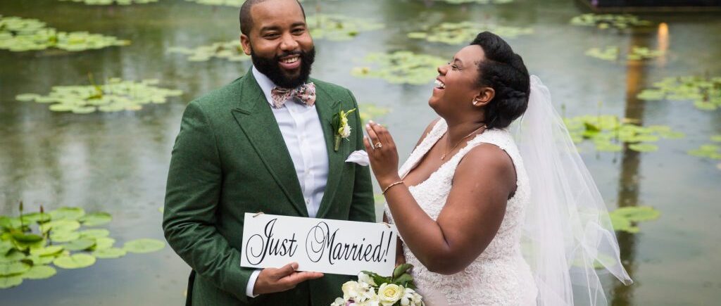 Bride and groom with 'Just Married' sign for an article on destination wedding photography tips
