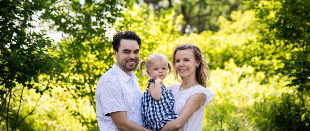 Parents holding child in Forest Park for article on pandemic portrait session details