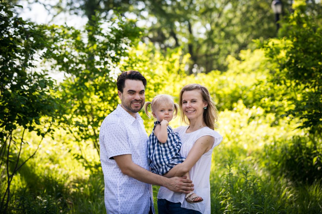 Parents holding child in Forest Park for article on pandemic portrait session details