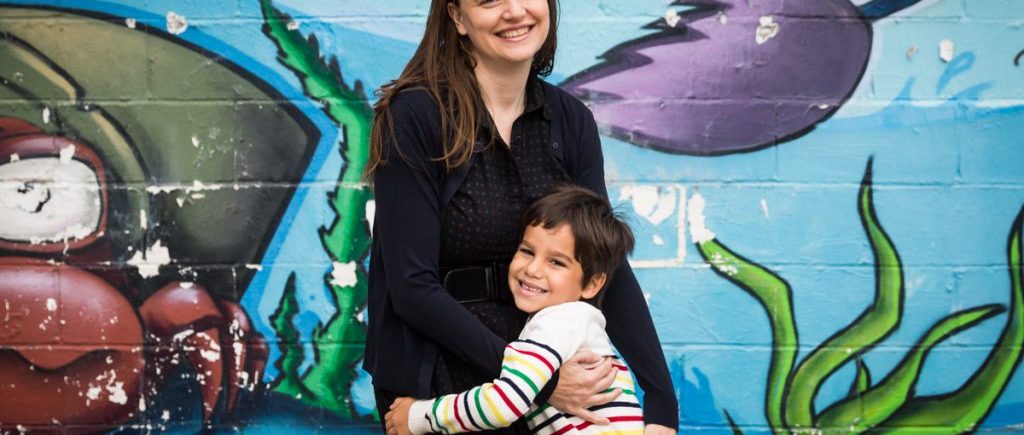 Mom and son hugging in front of colorful mural during a Gowanus family portrait session