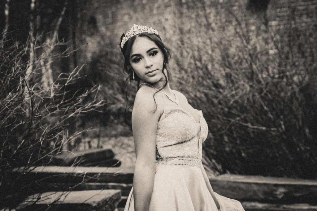 Black and white photo of girl wearing ball gown and crown