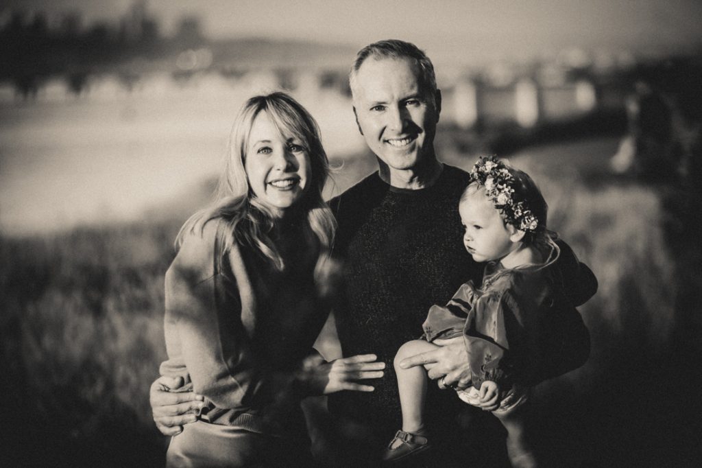 Black and white photo of parents holding little girl