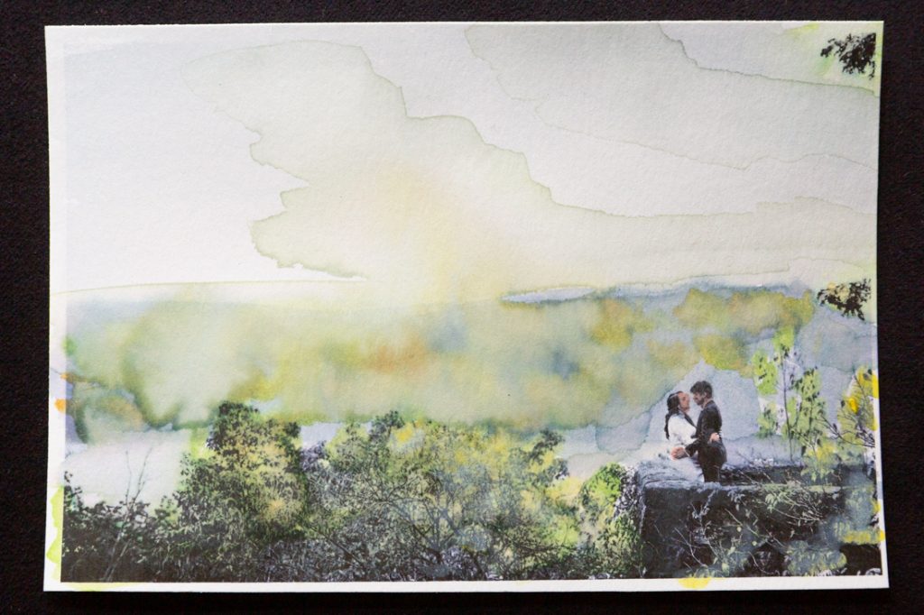 Hand-colored image of couple hugging against stone wall