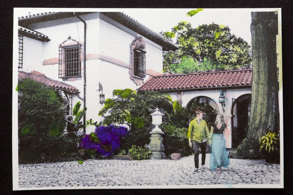 Hand-colored image of couple walking across stone patio