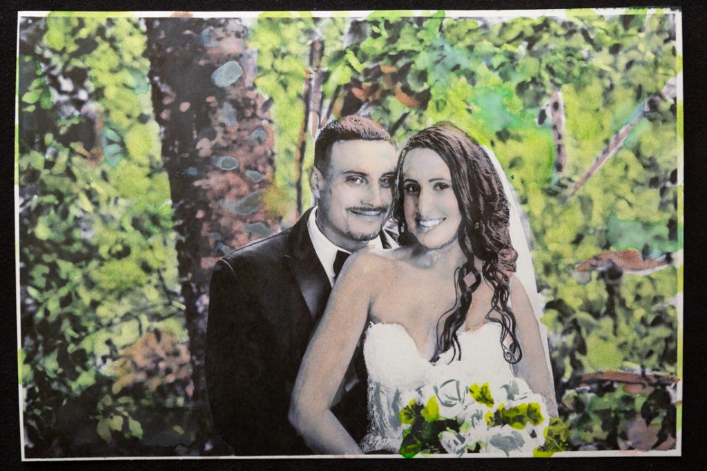 Hand-colored image of bride and groom in front of trees