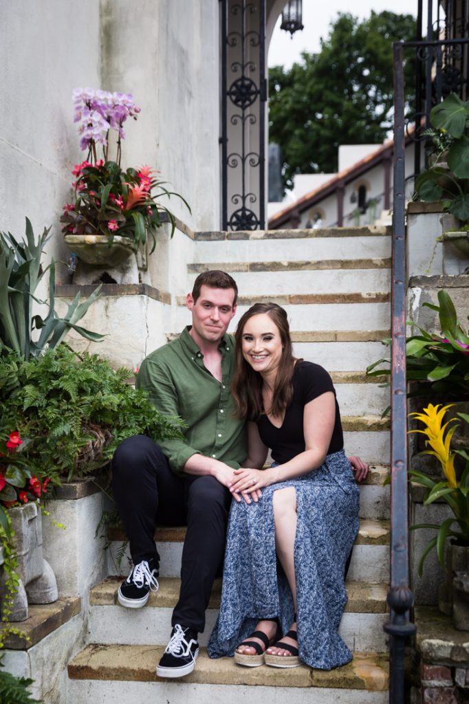 An engaged couple sitting on a stone staircase for an article on hand-colored black and white images