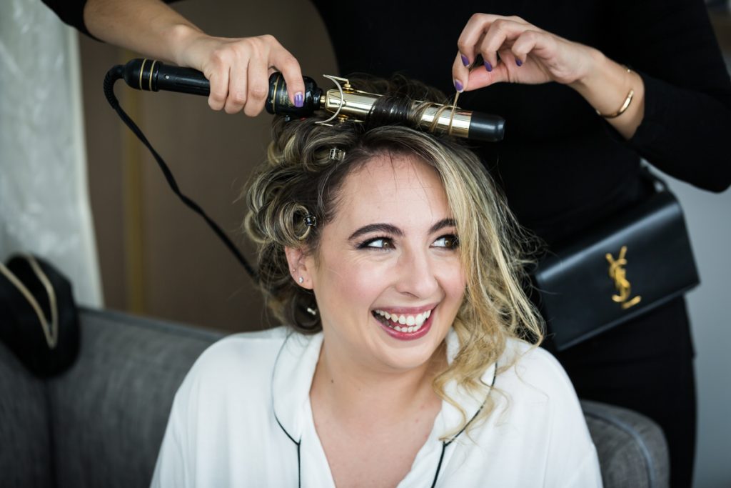 Bride having hair curled with iron before Brooklyn Winery wedding