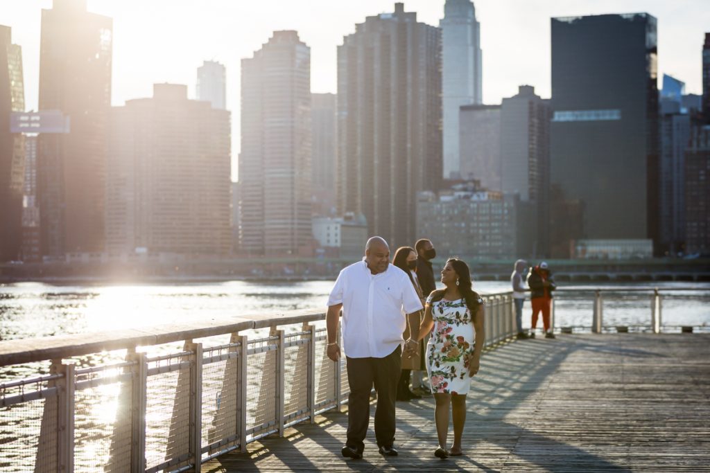 Couple walking along pier during a Long Island City maternity portrait session