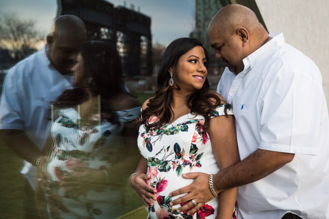 Couple reflected in window during a Long Island City maternity portrait session