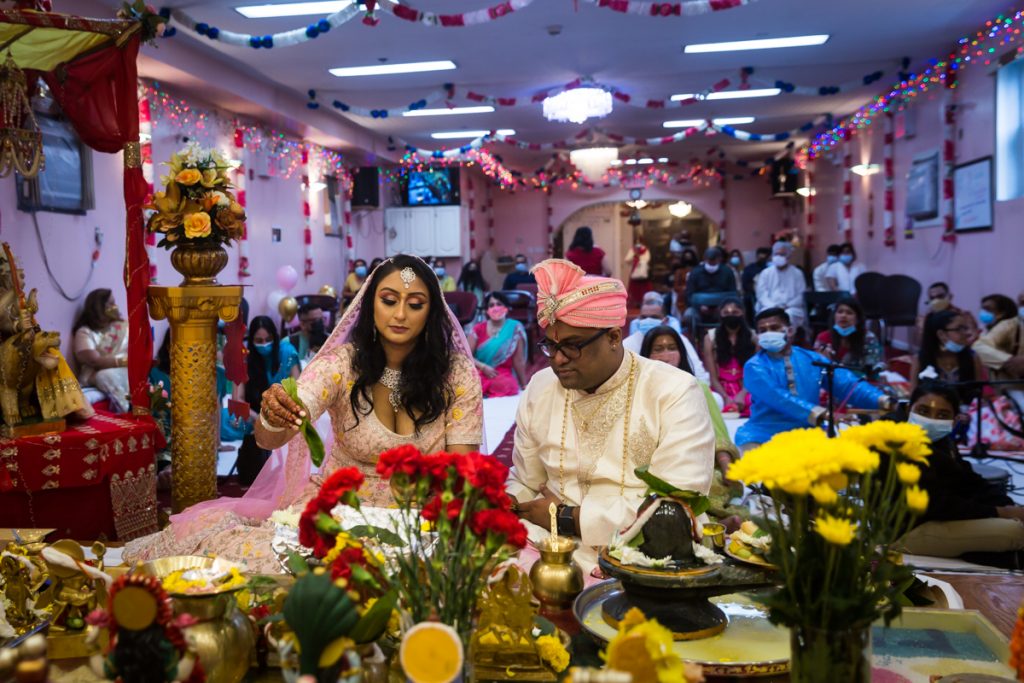 Bride and groom performing sagai rituals in front of audience