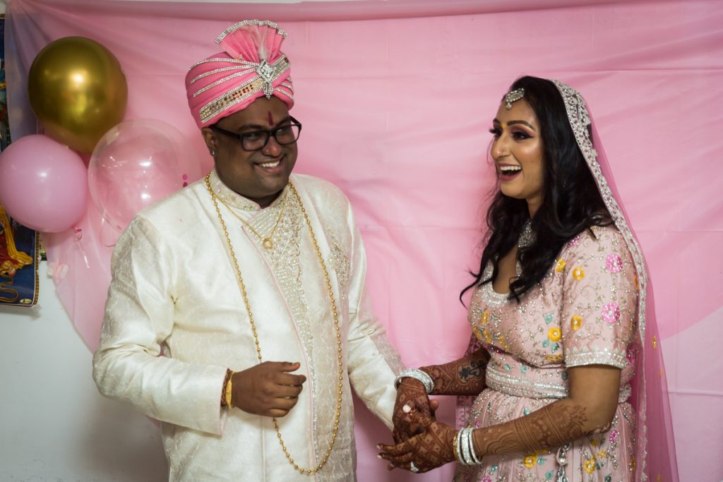 Traditional Indian bride and groom laughing during reception