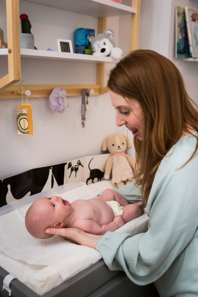 Mother looking at newborn baby on changing table