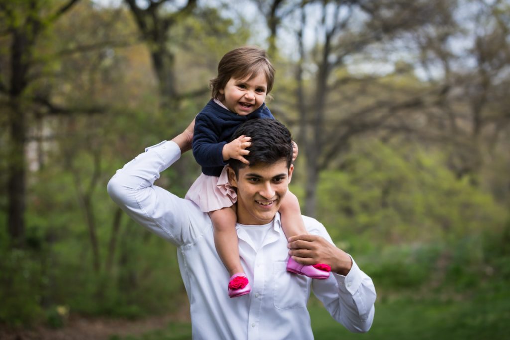 Young man holding little girl on his shoulders for an article on NYC family portrait location ideas