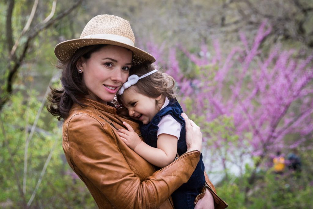 Woman wearing hat and holding baby girl for an article on NYC family portrait location ideas