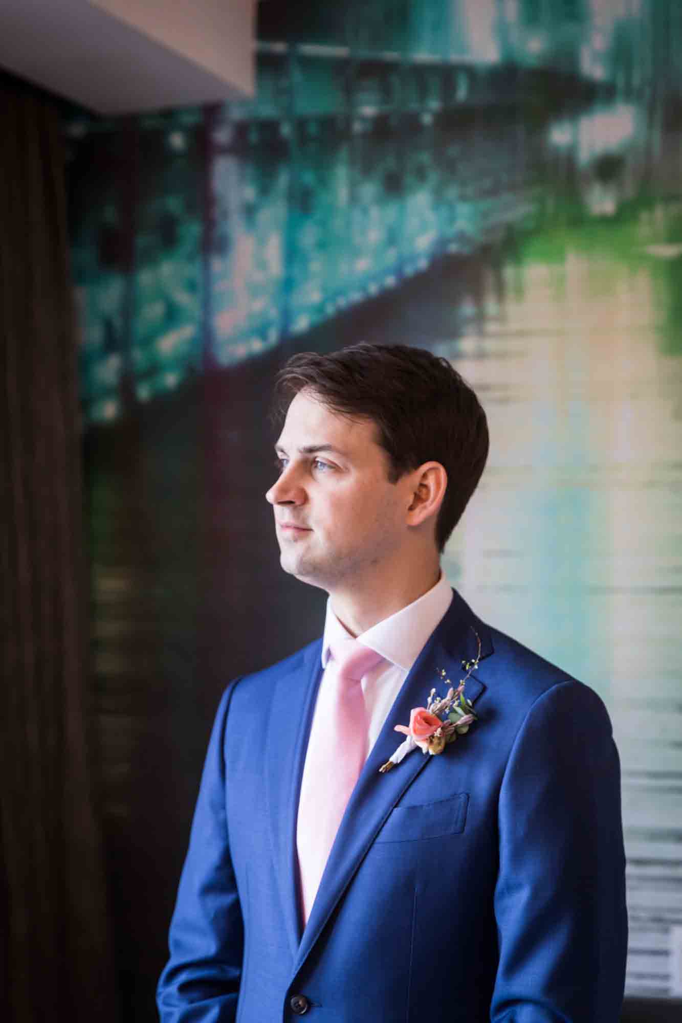 Groom wearing pink tie looking to the side