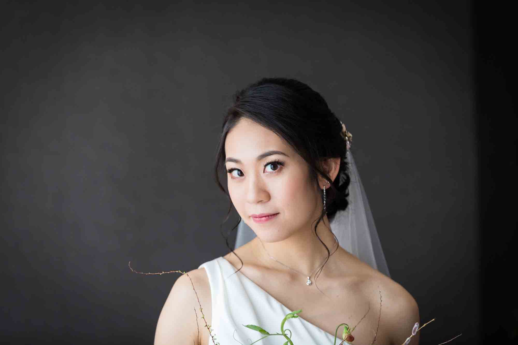 Bride wearing one-shoulder dress and veil