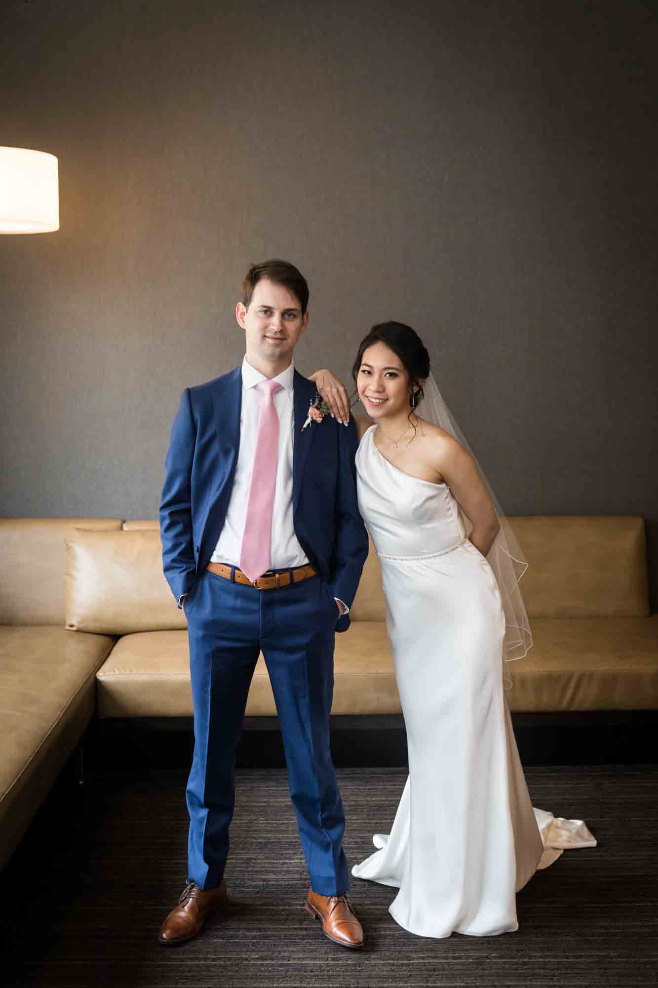 Bride leaning on groom's shoulder in front of couch