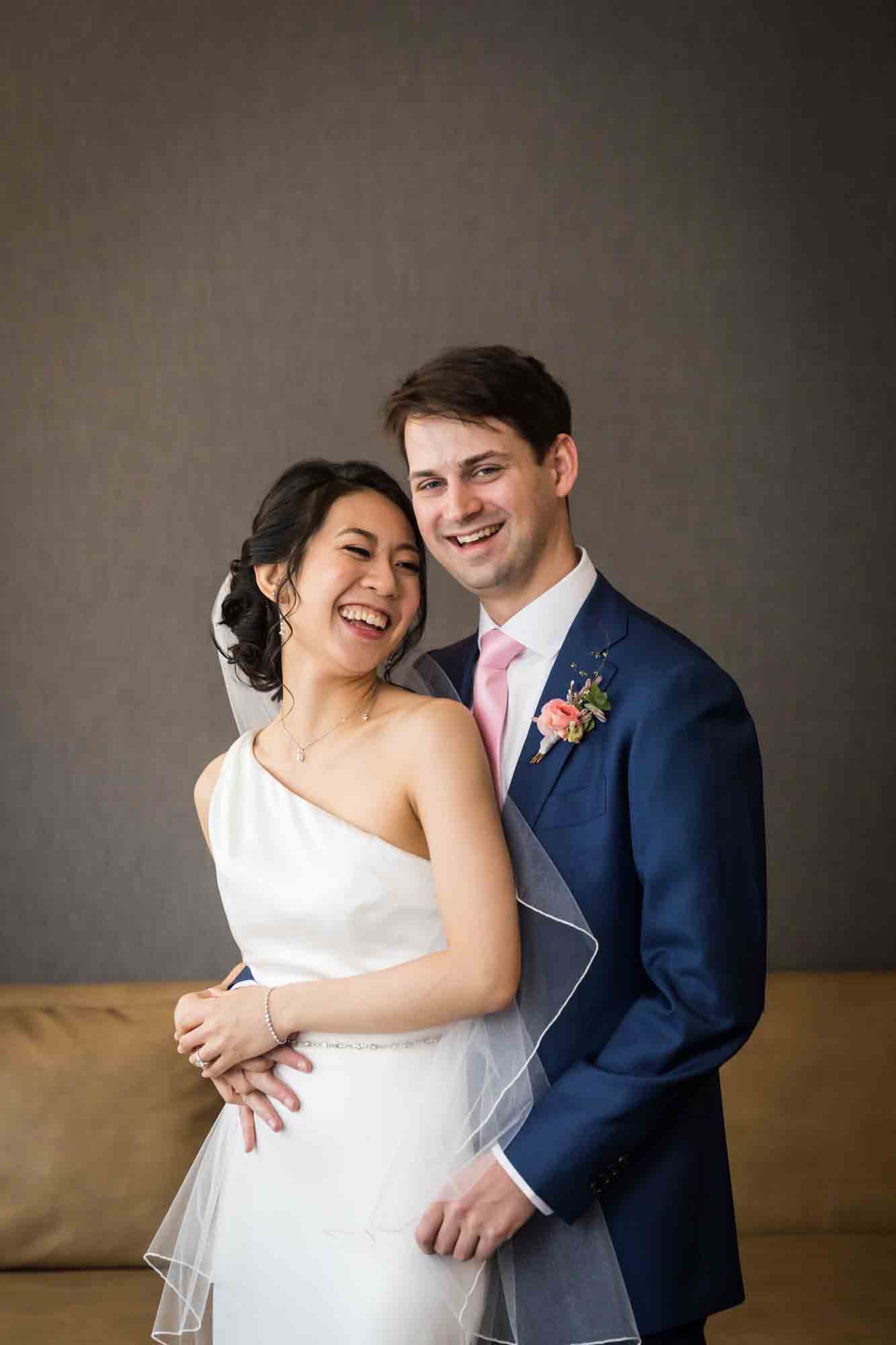Bride and groom posed in front of couch
