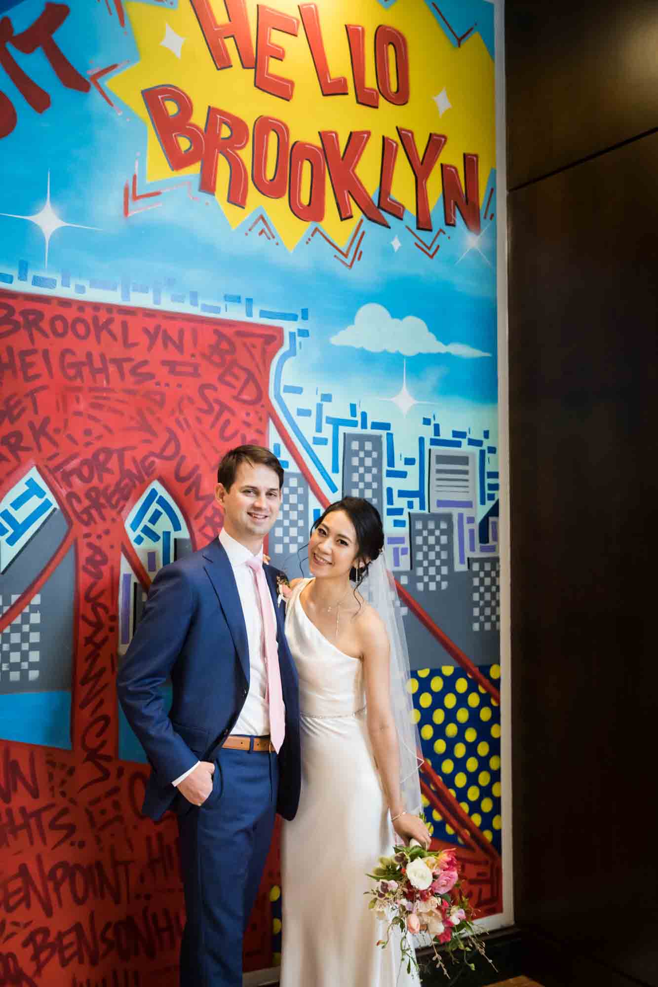 Bride and groom in front of graffiti wall