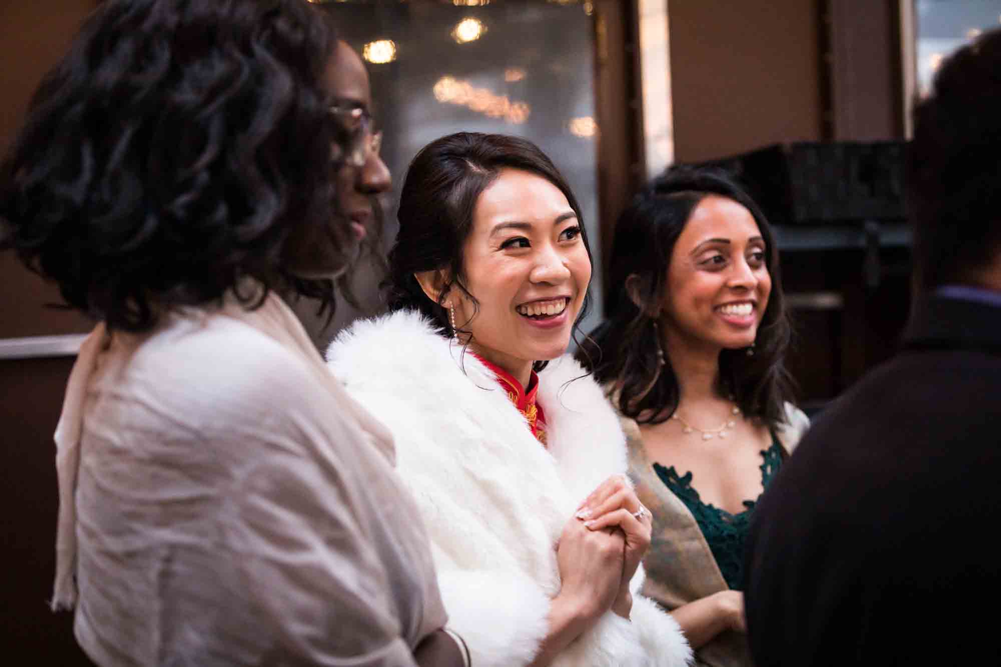 Bride and two female guests laughing at a Brooklyn restaurant wedding