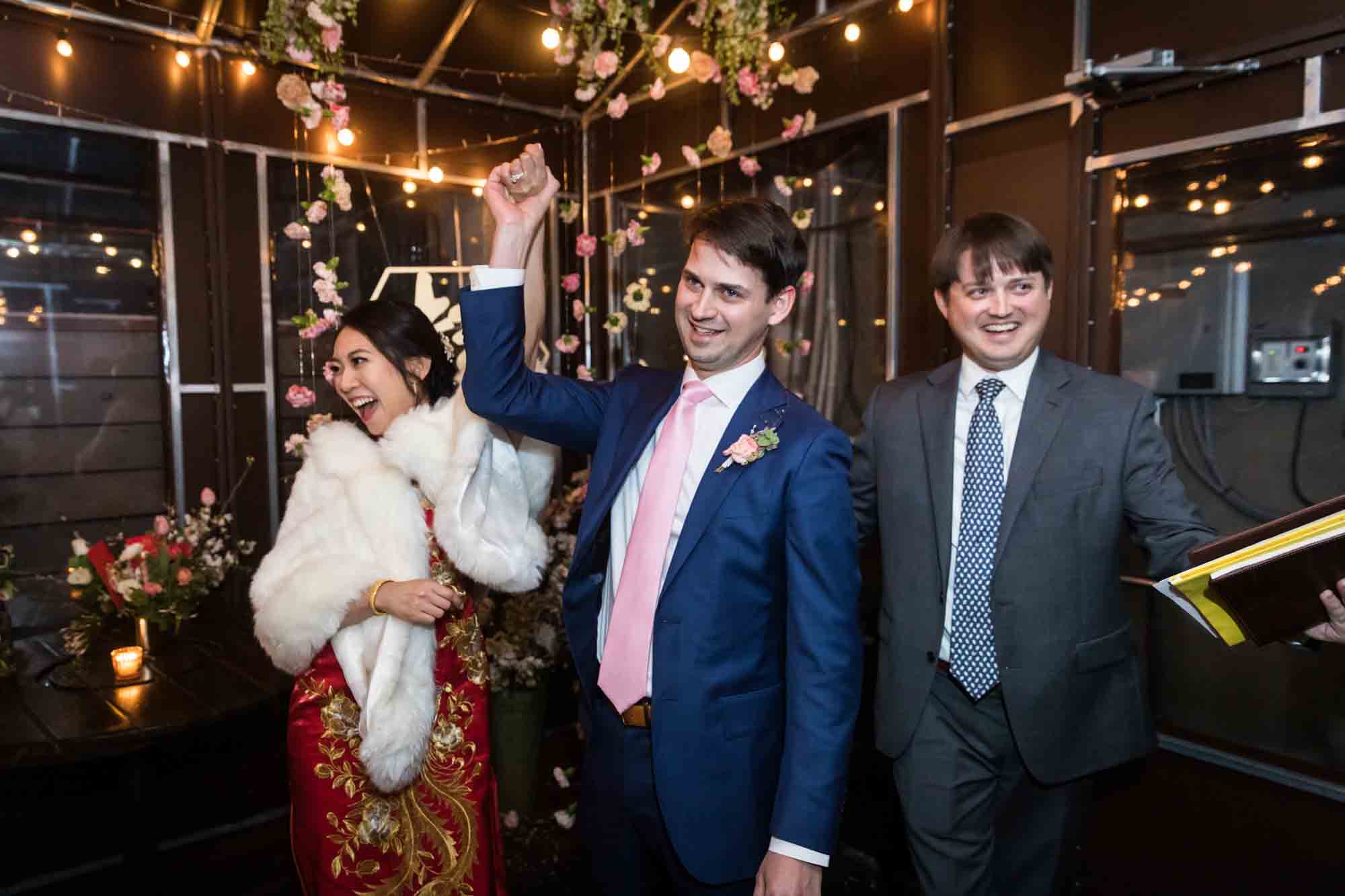 Bride and groom raising hands after Brooklyn wedding ceremony