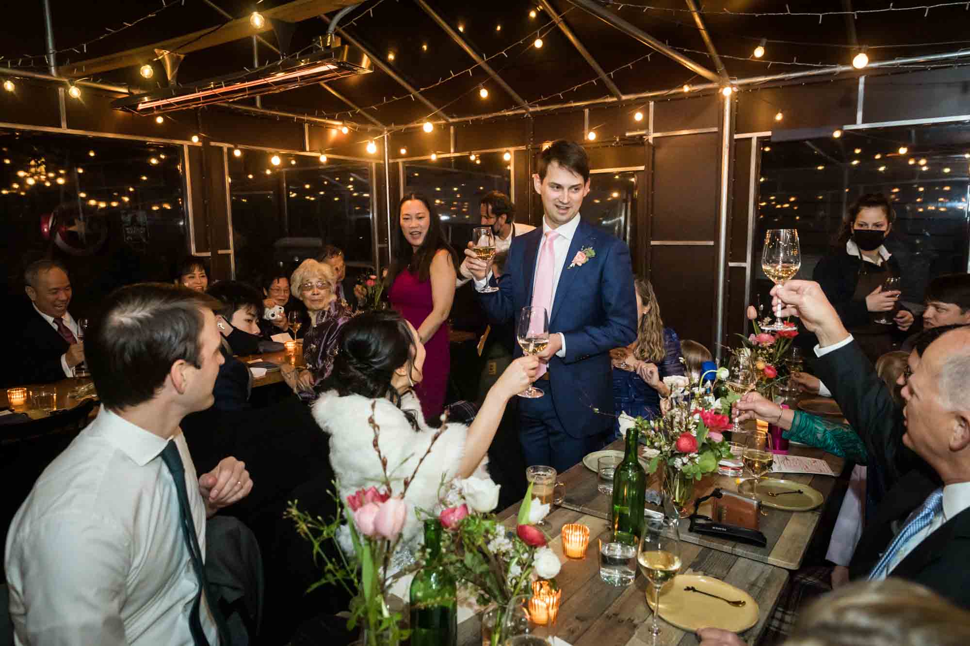 Guests toasting with glasses at a Brooklyn restaurant wedding