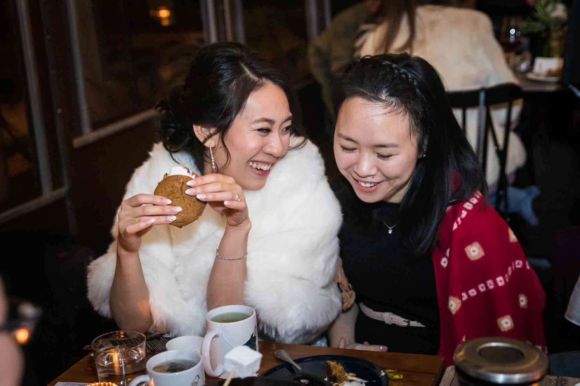 Bride and female guest laughing at a Brooklyn restaurant wedding