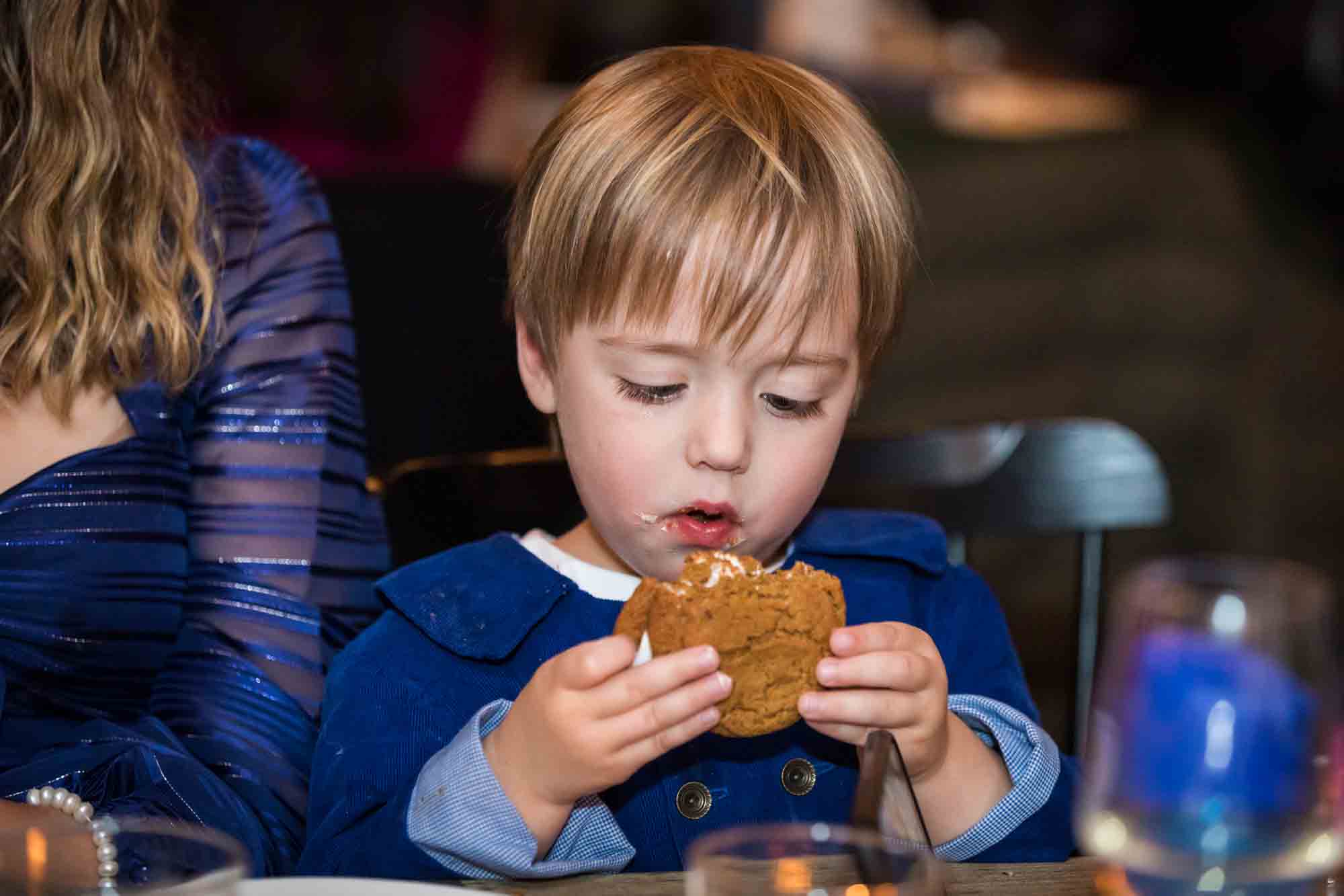 Little boy eating a s'more at a Brooklyn restaurant wedding