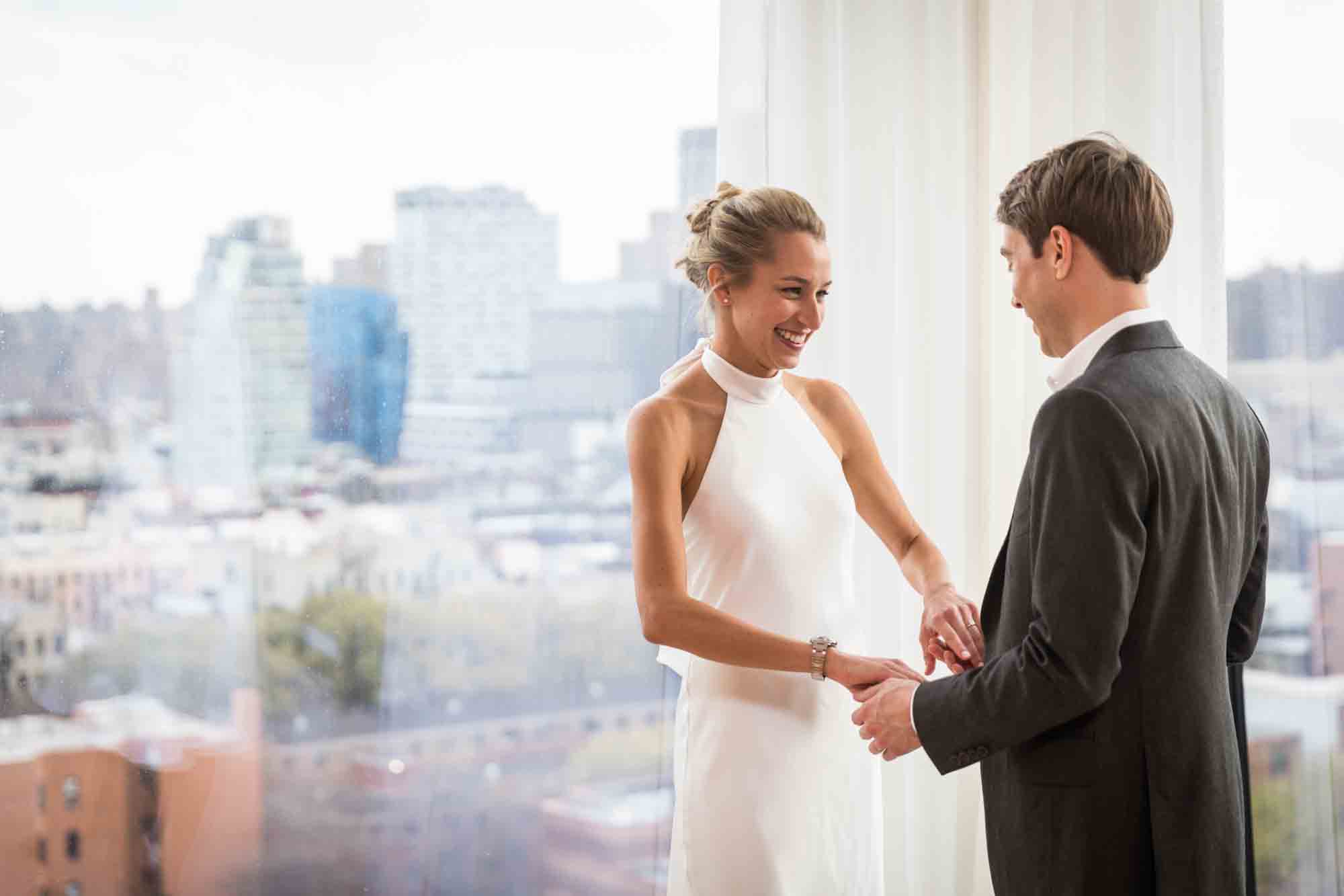 Bride and groom holding hands in front of windows before their Public Hotel wedding
