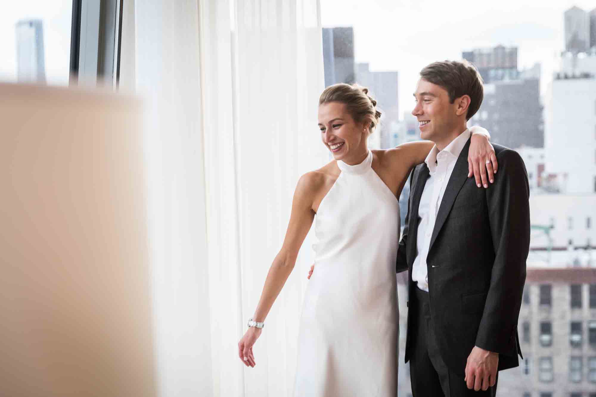 Bride and groom in front of white curtain before their Public Hotel wedding