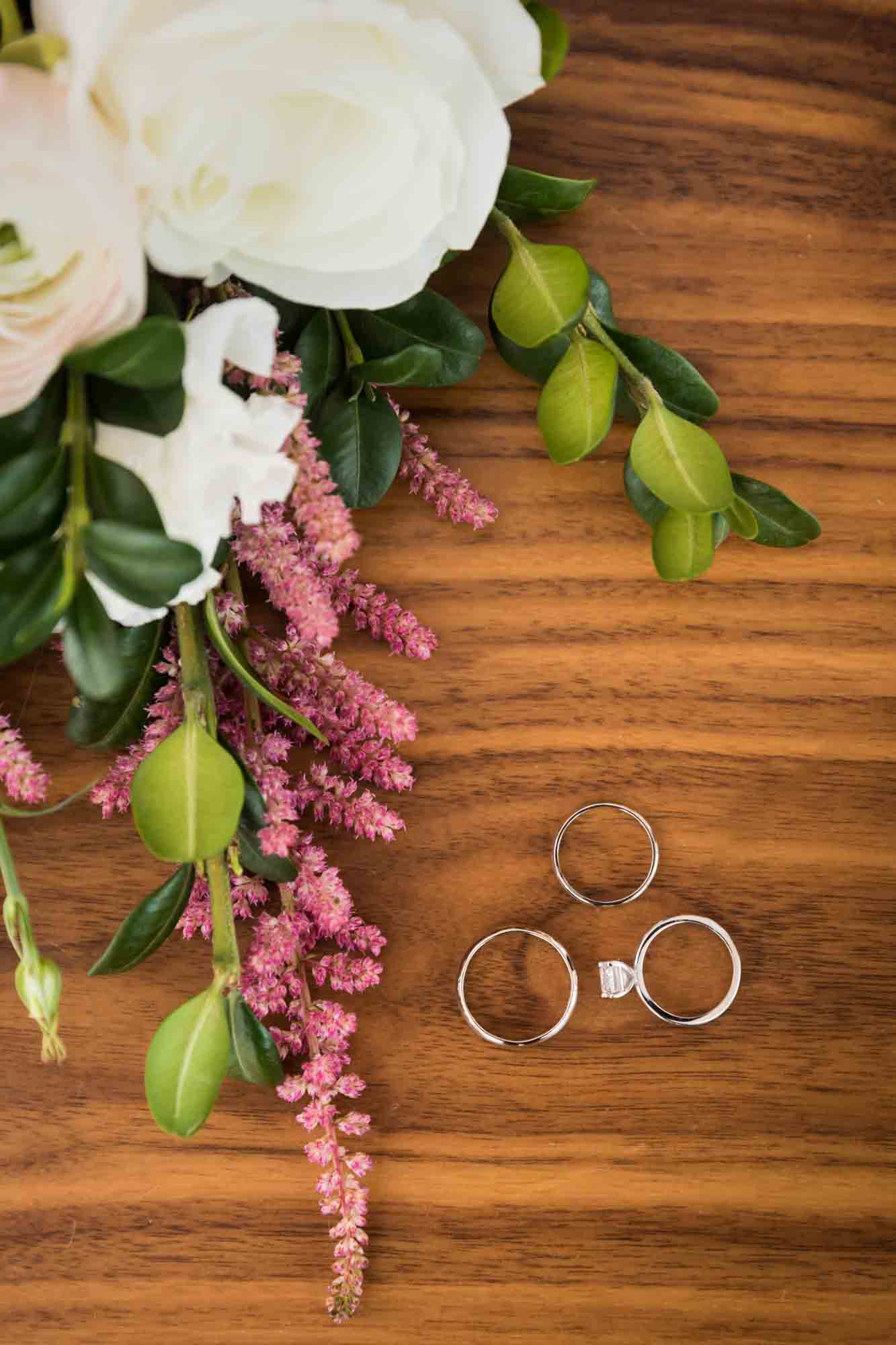 Table with flower bouquet and three rings before a Public Hotel wedding