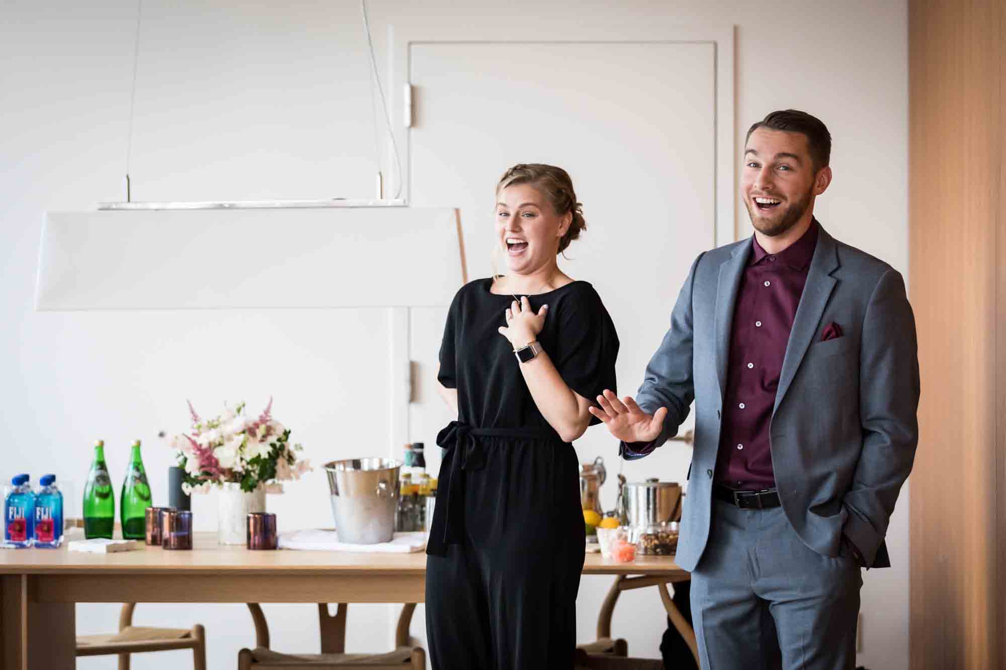 Couple looking surprise in front of table in hotel room